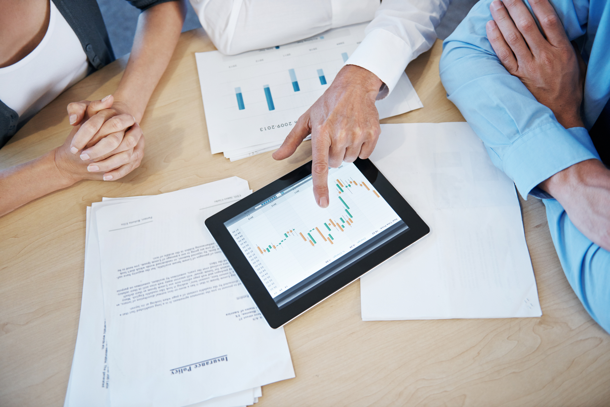 Cropped shot of business people going over statistics on a digital tablet