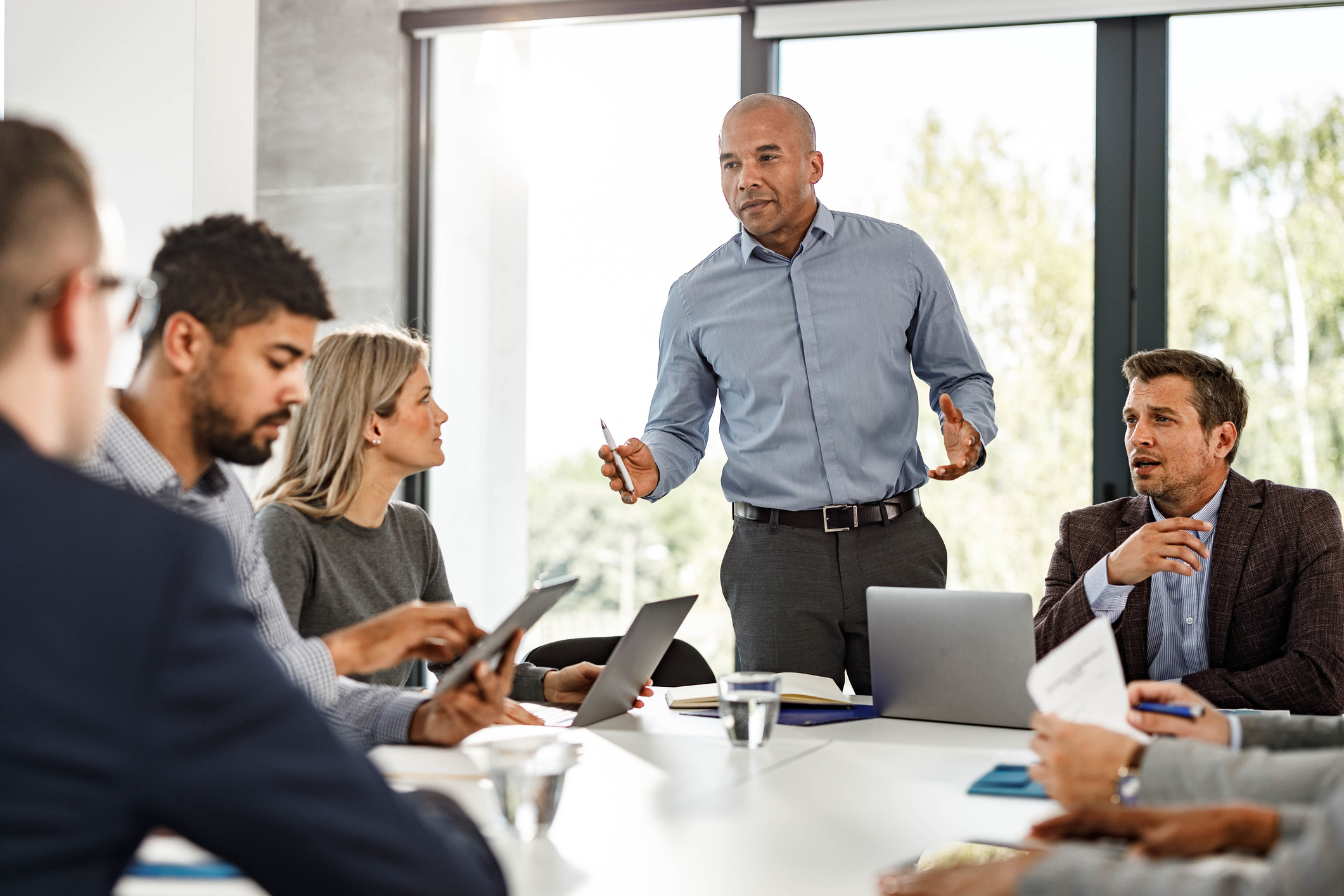 Mid adult black businessman giving a speech to his colleagues during a meeting in the office.