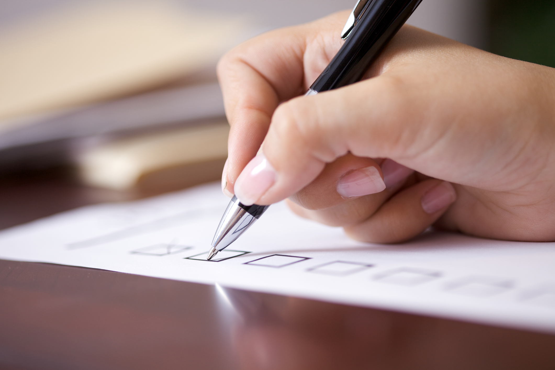 Woman at desk checking off her to do list.