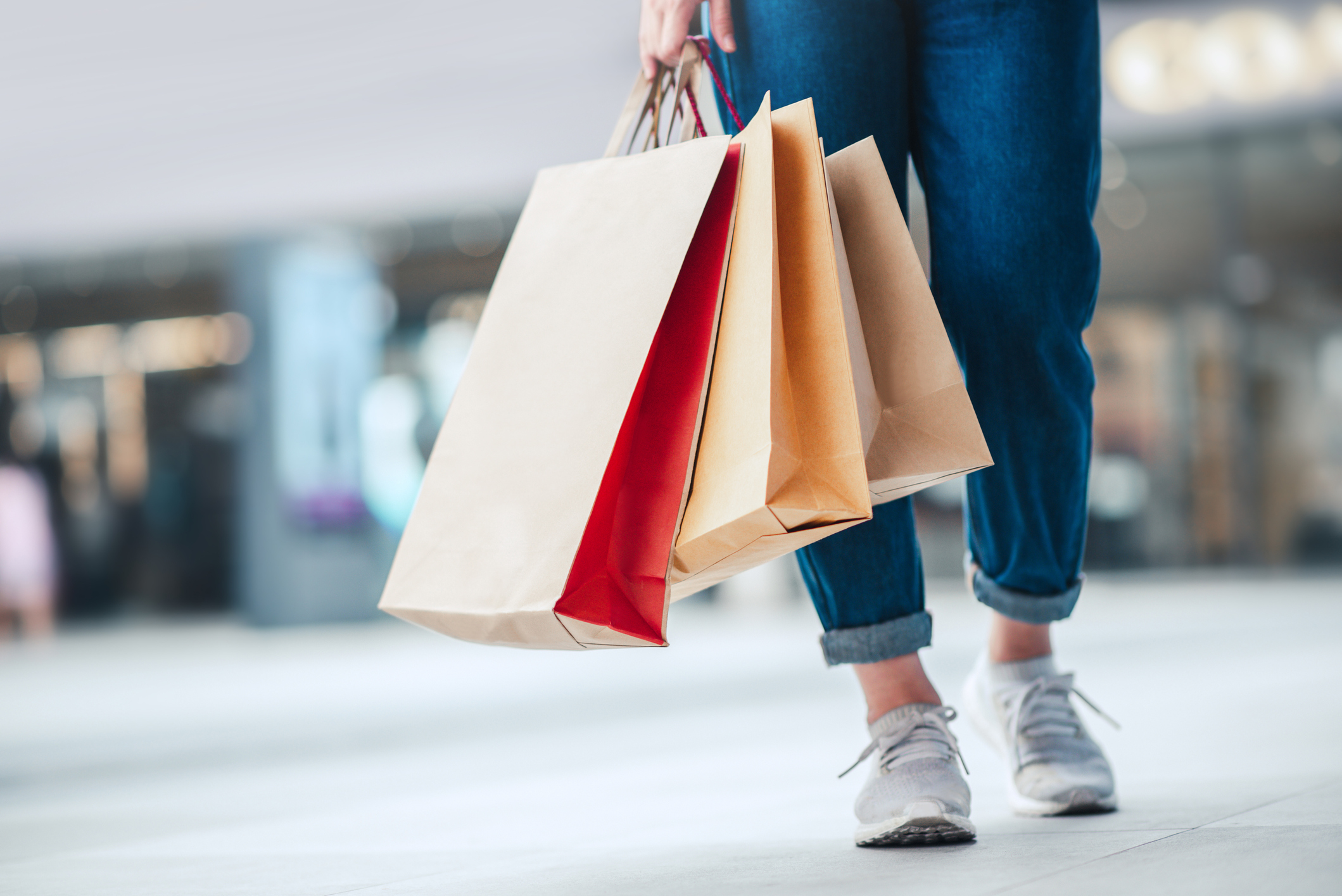 Closeup - Woman holding sale shopping bags. Consumerism, shopping, lifestyle concept