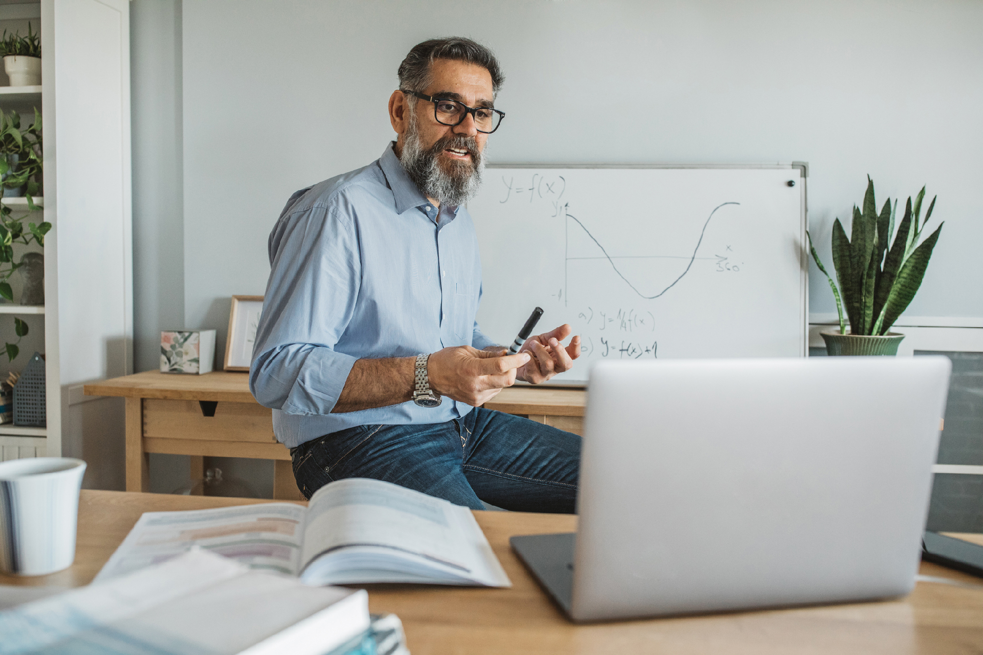 Mature men at home teaching students remotely