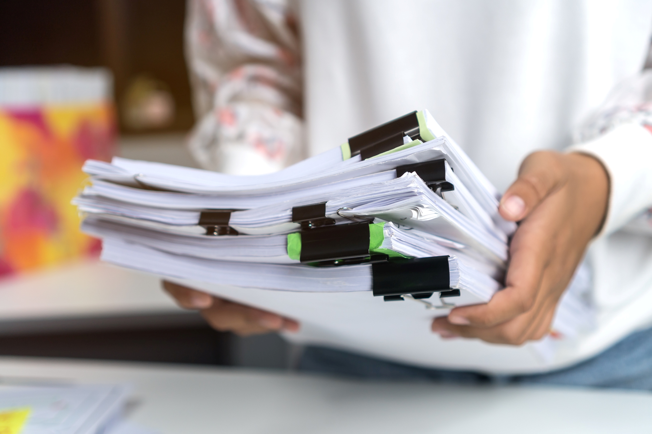 Stacks of hard copy files signifying document management.